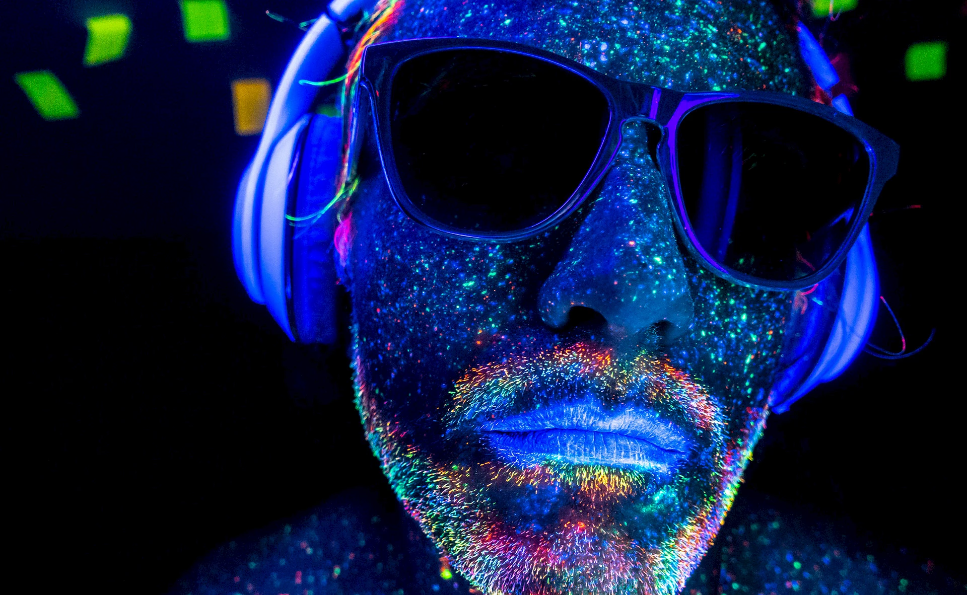 DJ with headphones under UV lights.