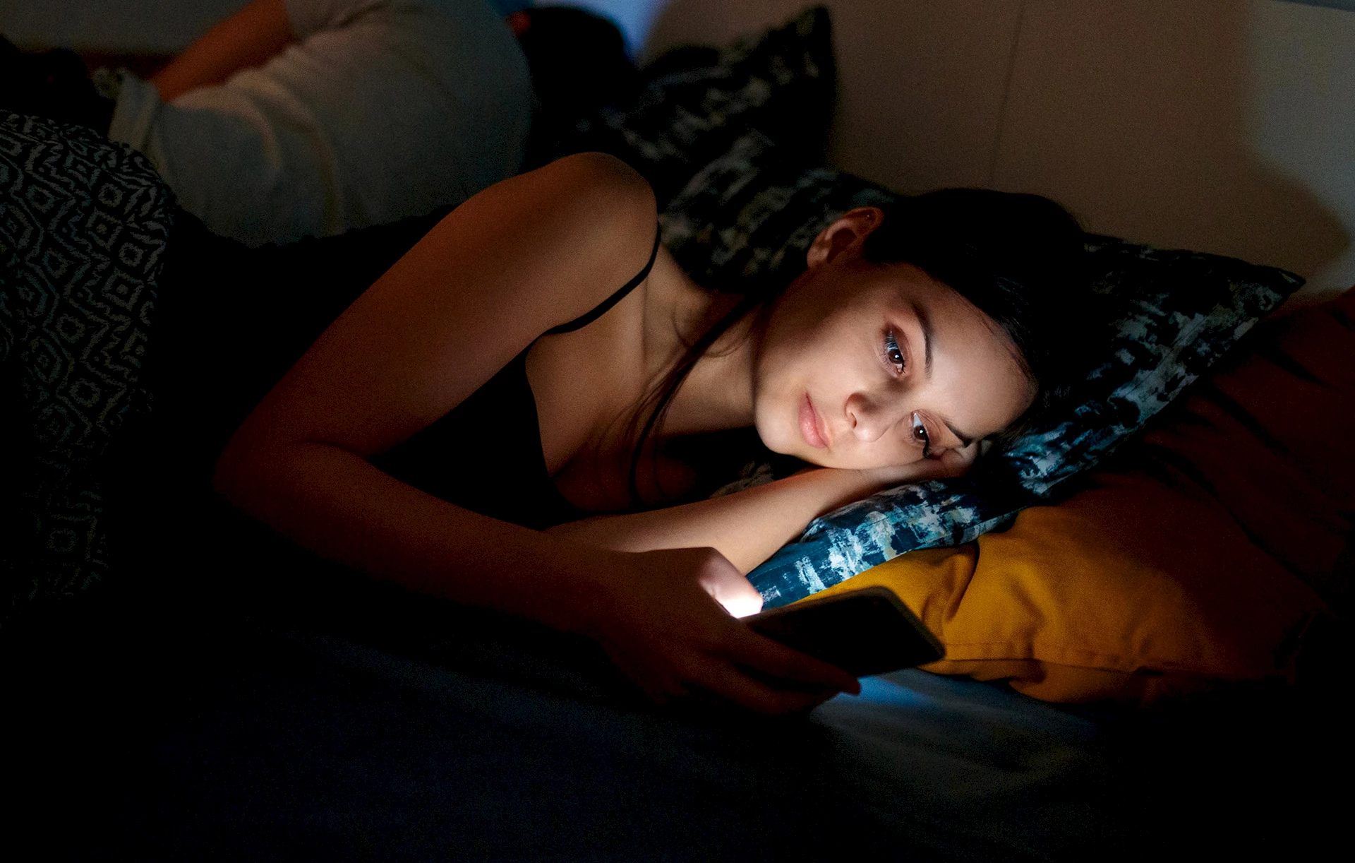 Woman checking her smartphone at bedtime.